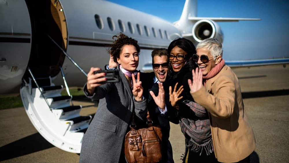 Group of people taking selfie by private jet